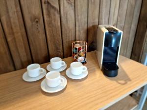 uma mesa com três chávenas de café e uma torradeira em CalaRosa Condomínio em Praia do Rosa