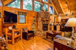 un salon avec cheminée dans une cabane en rondins dans l'établissement Beary Cozy Cabin, à Sevierville