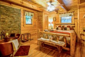 a bedroom in a log cabin with a bed and a tub at Beary Cozy Cabin by Venture Smoky Mountains in Sevierville