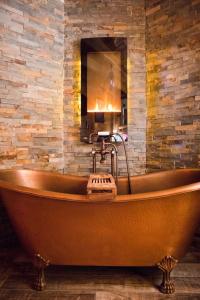 La salle de bains est pourvue d'une grande baignoire et d'un mur en pierre. dans l'établissement Beary Cozy Cabin, à Sevierville