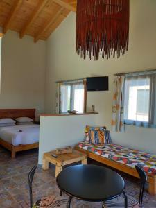 una habitación con dos camas y una mesa y un sofá en Pension Gabino (rooms), en El Ganso