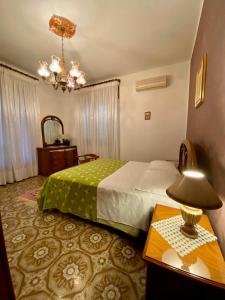 - une chambre avec un lit et une table avec une lampe dans l'établissement Villa Maria - Sant'Angelo di Brolo, à Contura