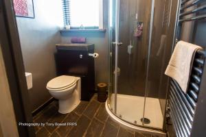 a small bathroom with a toilet and a shower at Hove Art Deco Spacious House in Brighton & Hove
