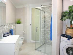 a bathroom with a shower and a washing machine at Residence Green Life in Bibione