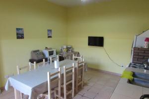 a dining room with a table and chairs and a tv at Hostel Céntro Belén in Belén