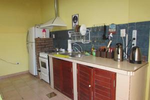 a kitchen with a sink and a refrigerator at Hostel Céntro Belén in Belén