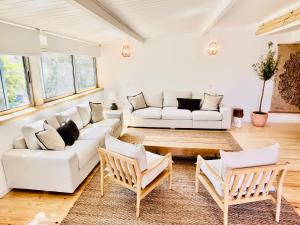 a living room with a white couch and chairs at Salema Eco Camp - Sustainable Camping & Glamping in Salema