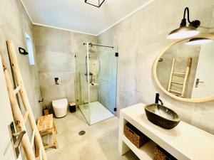 a bathroom with a sink and a glass shower at Salema Eco Camp - Sustainable Camping & Glamping in Salema +132 photos