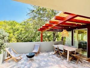 a patio with a wooden table and chairs at Salema Eco Camp - Sustainable Camping & Glamping in Salema