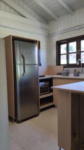 uma grande cozinha com um frigorífico de aço inoxidável em CalaRosa Condomínio em Praia do Rosa