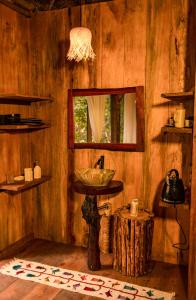 a bathroom with a mirror and a sink in a room at AWAKEN Amazonian Healing Resort ALL INCLUSIVE in Iquitos