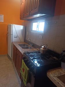 uma cozinha com um fogão e uma chaleira. em Hospedaje Turisticos. em Libertador General San Martín