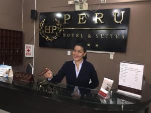 una mujer sentada en un mostrador en un hotel en Peru Hotel & Suites, en Pisco