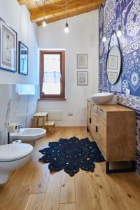 łazienka z 2 umywalkami, toaletą i dywanem w obiekcie L'Oasi nel Borgo w mieście Monteroduni