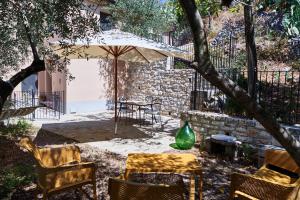 patio ze stołem, krzesłami i parasolem w obiekcie L'Oasi nel Borgo w mieście Monteroduni