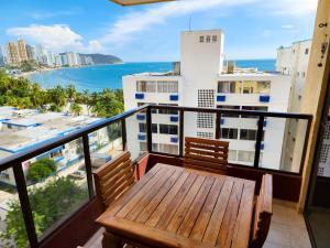 a balcony with a wooden table and a view of the ocean at Apartamentos cerca a la playa, Los Laureles - By Bedviajes in Santa Marta +57 photos
