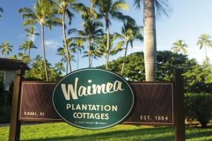 a sign in front of a palm tree at Waimea Plantation Cottages, a Coast Resort in Waimea