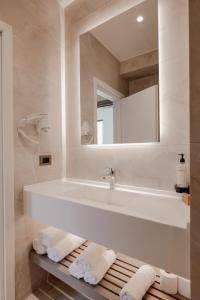 a white bathroom with a sink and a mirror at JOST Caravel in Vlorë