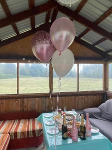zwei Ballons auf einem Tisch mit Flaschen Champagner in der Unterkunft Pūrmalas 