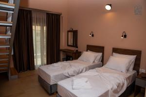 - 2 lits dans une chambre d'hôtel avec des draps blancs dans l'établissement Old Nikiti's Hotel, à Nikiti