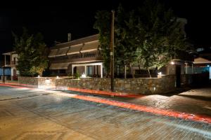 - une piscine de nuit avec un bâtiment dans l'établissement Old Nikiti's Hotel, à Nikiti
