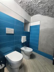 a bathroom with a toilet and a blue wall at Casale Forno Vecchio in Tramonti