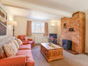 a living room with a couch and a brick fireplace at Redwood Cottage in Covington