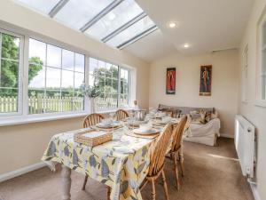 een eetkamer met een tafel, stoelen en ramen bij Redwood Cottage in Covington