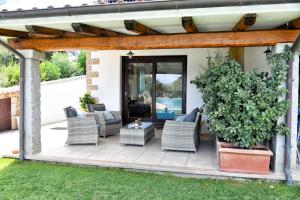 a patio with wicker chairs and a table at My Opera Private Pool by Sarda Bella in Rudalza