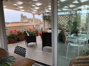 een balkon met een tafel en stoelen op een patio bij Attico Da Rosa con vista spettacolare a 360 gradi in Caltagirone