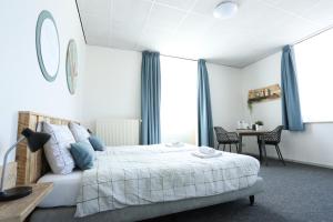 1 dormitorio con 1 cama y 1 mesa con sillas en Vitaliteitscentrum Brabant, en Vierlingsbeek