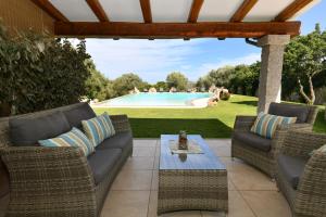 a patio with wicker furniture and a swimming pool at My Opera Private Pool by Sarda Bella in Rudalza