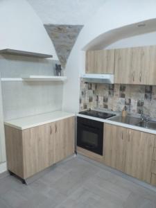 una cocina con armarios de madera y fregadero en LUCIA HOME CASA VACANZE, en Santa Maria del Molise