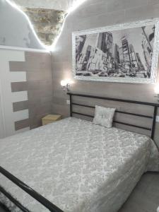 1 dormitorio con 1 cama y una foto en la pared en LUCIA HOME CASA VACANZE, en Santa Maria del Molise