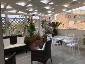a patio with a table and chairs on a balcony at Attico Da Rosa con vista spettacolare a 360 gradi in Caltagirone