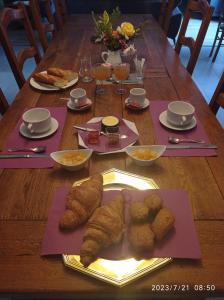 - une table avec des pâtisseries et des assiettes de nourriture dans l'établissement les tonneaux de Lisores, à Lisores