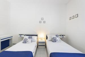 2 camas en una habitación con paredes blancas en Casa Giovanna by Wonderful Italy en Bari