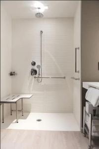 a shower stall in a bathroom with a desk at AC Hotel by Marriott San Jose Downtown in San Jose