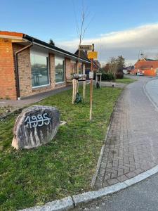 Una roca con graffiti al lado de una calle en Übernachtunsmöglichkeit, en Hamdorf