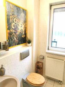 a bathroom with a toilet and a painting on the wall at Jules Heim mit Herz in Hanshagen