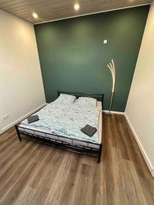 Cama en habitación con pared verde en Übernachtunsmöglichkeit, en Hamdorf