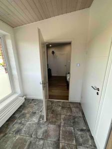 an empty hallway with a hallway leading to a room at Übernachtunsmöglichkeit in Hamdorf