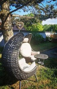 a wicker chair and a table in a yard at Jules Heim mit Herz in Hanshagen