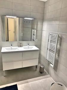 Appartement neuf, Monaco avec vue mer في بوسولاي: حمام مغسلتين ومرآة