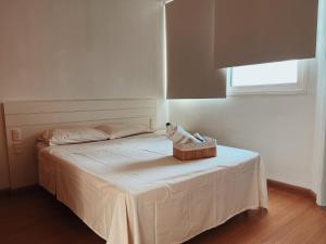 Un dormitorio con una cama con una caja. en BH PARA 2 - STUDIO - Estoril, en Belo Horizonte