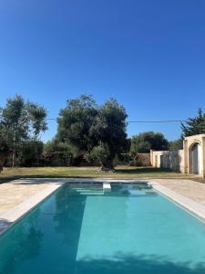 a large blue swimming pool in a yard at Masseria Conca D'Oro in Ostuni