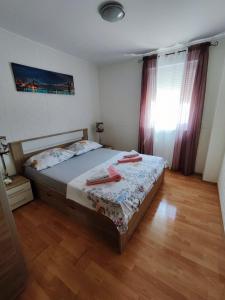 - une chambre avec un lit et des serviettes rouges dans l'établissement Apartman Marija Privlaka, à Privlaka