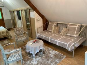 a bedroom with a bed and a table and chairs at Gîte Bien-être in Yquebeuf