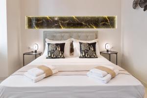 a bedroom with a white bed with two night stands at Modern-Vintage Old Town Suites in Corfu Town