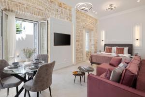 uma sala de estar com um sofá, uma cama e uma mesa em Modern-Vintage Old Town Suites em Corfu Town